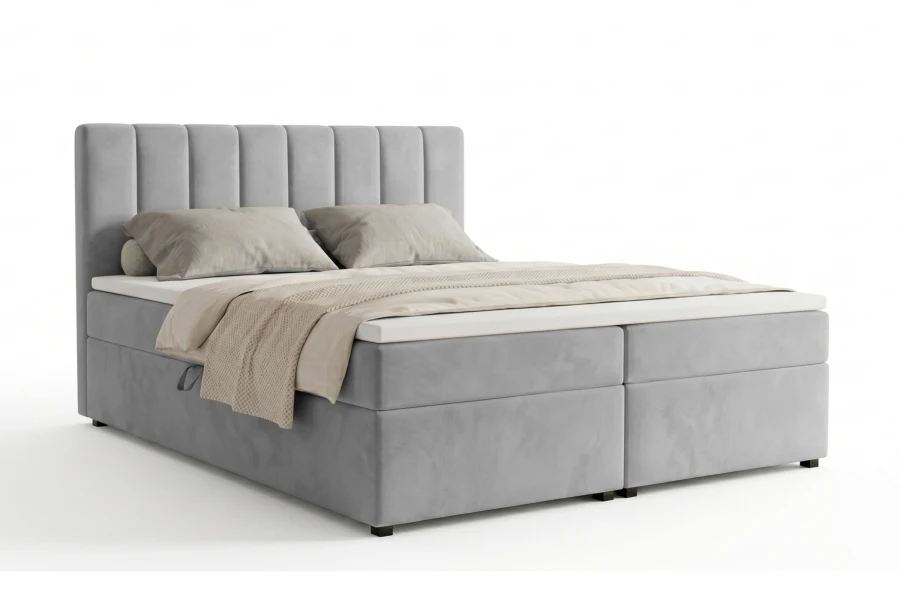 Graues Boxspringbett mit hohem Kopfteil auf weißem Hintergrund