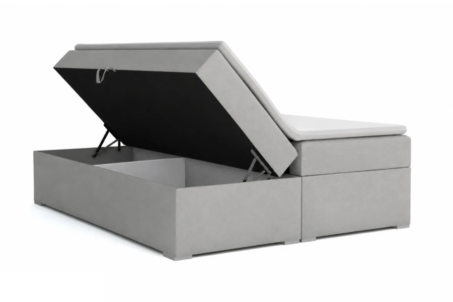 Graues Boxspringbett mit geöffnetem Bettkasten für praktischen Stauraum.