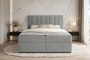 Modernes hellgraues Boxspringbett mit gestepptem Kopfteil in einem eleganten Schlafzimmer.