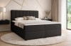 Modernes Schlafzimmer mit schwarzem Boxspringbett und goldener Wanddeko.