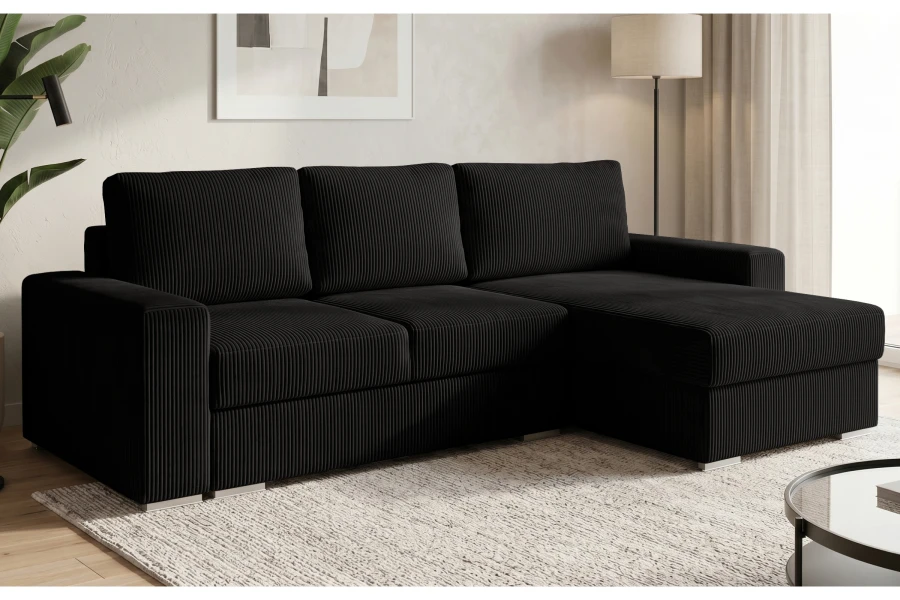 Modernes Ecksofa in Schwarz aus Cord-Stoff in einem hellen Wohnzimmer.