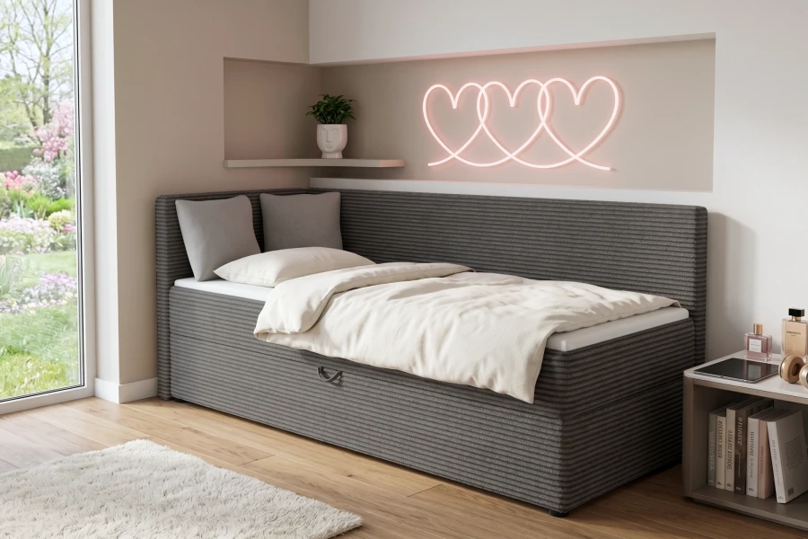 Stilvolles anthrazitfarbenes Cord-Schlafsofa mit Bettkasten und Herz-Neonlicht im Hintergrund.