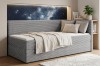 Modernes graues Schlafsofa vor einer beleuchteten Wandnische mit Sternenhimmel-Motiv.