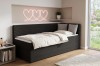 Schwarzes Daybed aus Cord mit Bettkasten im hellen Zimmer mit leuchtender Herz-Wanddeko.