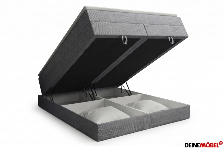 Graues Boxspringbett mit weit geöffnetem Bettkasten für extra Stauraum.