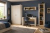 Stylisches Jugendzimmer in Dunkelblau mit beigem Schreibtisch, Kleiderschrank und Skateboard.