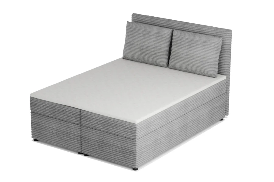 Modernes hellgraues Boxspringbett aus Cordstoff mit Kopfteil und Kissen, schräge Ansicht.