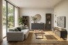 Helles, modernes Wohnzimmer mit gemütlichem Sofa und einer Möbelserie in Anthrazit-Eiche-Kombination.