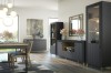 Modernes Esszimmer mit anthrazitfarbenen Möbeln, Vitrine und Sideboards auf goldenen Füßen.