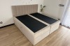 Beiges Boxspringbett-Untergestell ohne Matratzen in modernem Schlafzimmer mit Holzboden.