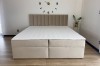 Modernes Boxspringbett VIKA in Beige mit vertikal gestepptem Kopfteil im Schlafzimmer.