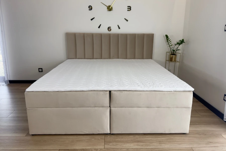 Modernes Boxspringbett VIKA in Beige mit vertikal gestepptem Kopfteil im Schlafzimmer.