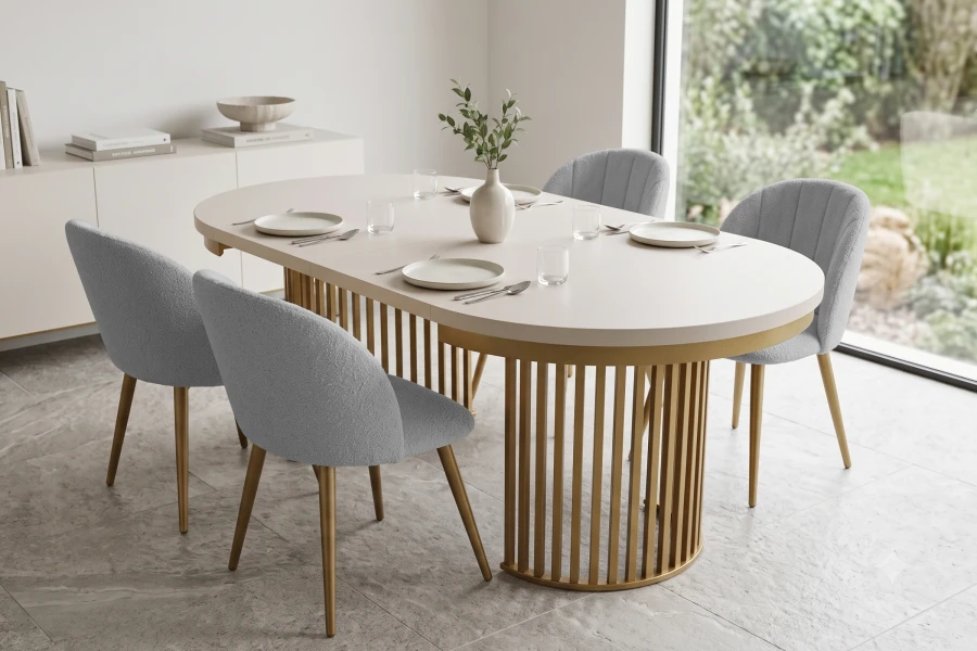 Eleganter ovaler Esstisch beige mit goldenem Gestell und grauen Stühlen.