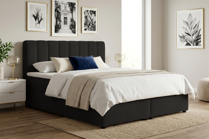 Modernes Boxspringbett in Schwarz mit Cord-Optik in einem hellen Schlafzimmer.