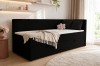 Elegantes schwarzes Daybed in hellem Zimmer mit rosa Dekoration und flauschigem Teppich.