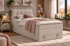Beiges Boxspringbett aus Cord in lichtdurchflutetem, gemütlichem Schlafzimmer.