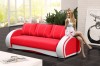 Modernes rotes Sofa mit weißen Akzenten in einem hellen Wohnzimmer.