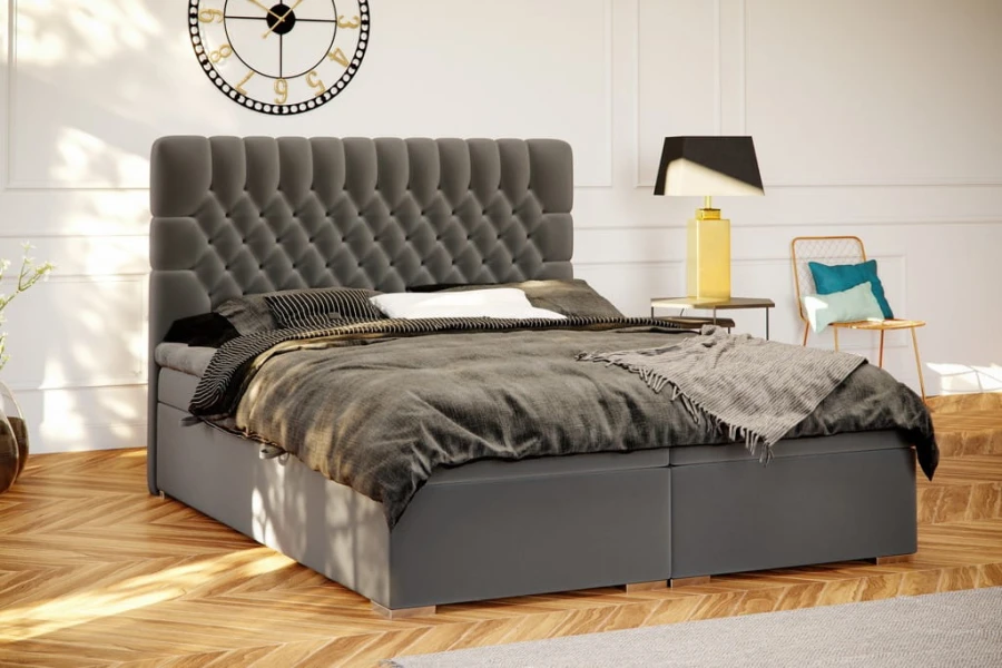 Anthrazitfarbenes Boxspringbett mit hohem, gestepptem Kopfteil in hellem Schlafzimmer.