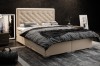 Beiges Boxspringbett mit Knopfheftung am Kopfteil in modernem Schlafzimmer.