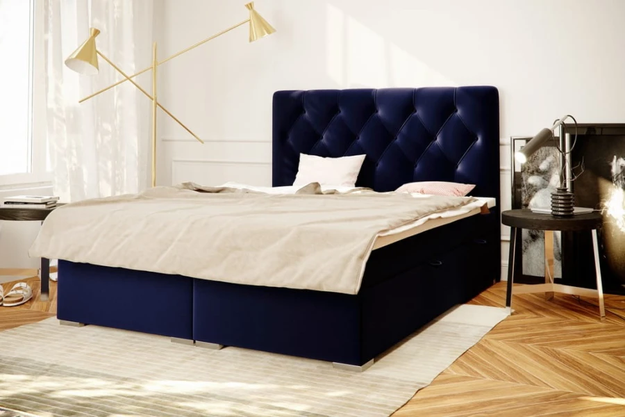Dunkelblaues Boxspringbett mit elegantem Rauten-Kopfteil in einem stilvollen Schlafzimmer.