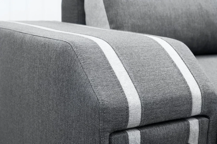 Nahaufnahme der hochwertigen Textilstruktur und hellen Designstreifen am Sofa.