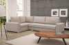 Beiges Ecksofa in gemütlicher Wohnzimmer-Atmosphäre mit hellem Teppich.