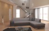 Zweifarbiges Ecksofa in Grau und Dunkelgrau vor einer modernen Treppe im Wohnzimmer.
