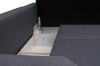 Nahaufnahme eines offenen Bettkastens bei einem grauen Schlafsofa.