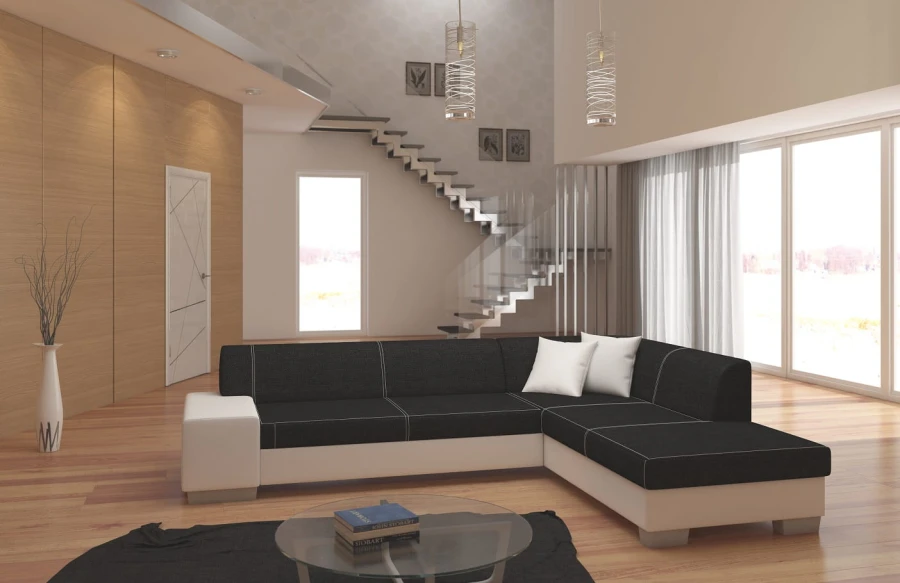 Modernes Ecksofa in Schwarz und Weiß in einem hellen Wohnzimmer mit Glastreppe.