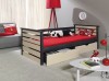 Graues Daybed mit hellen Holzfronten, Schubladen und roter Bettwäsche im gemütlichen Kinderzimmer.